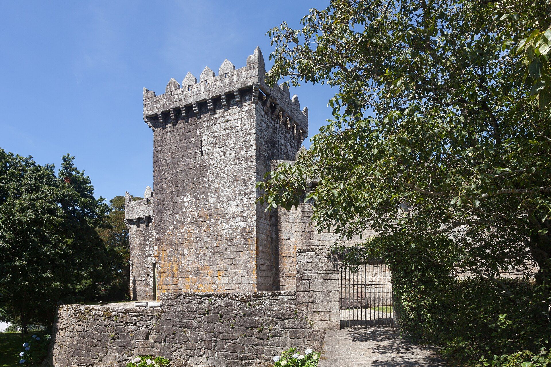 Torre da homenaxe do Castelo de Vimianzo vista desde o camiño de acceso, con matacáns e ameas de granito.