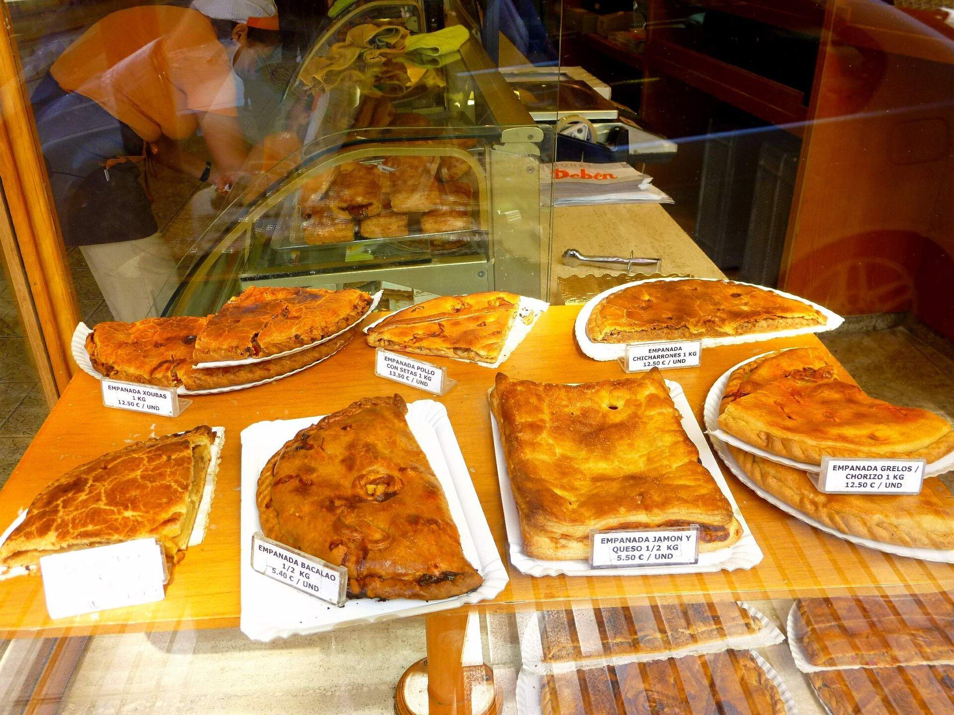 Bandexas con variedade de empanadas galegas nun mostrador.